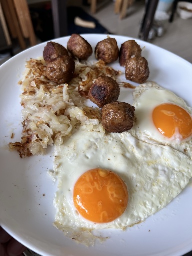 fried eggs with hash browns and meatballs